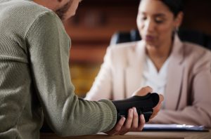 Man with injured wrist talking to lawyer.