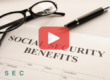 Close up of document with words: Social security benefits, glasses and pen.