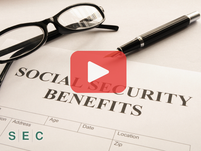Close up of document with words: Social security benefits, glasses and pen.