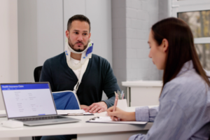 Man with neck injury in office space with woman.