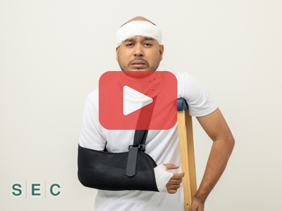 Injured Man with arm in a cast and crutch. Red play buttom and SEC logo.